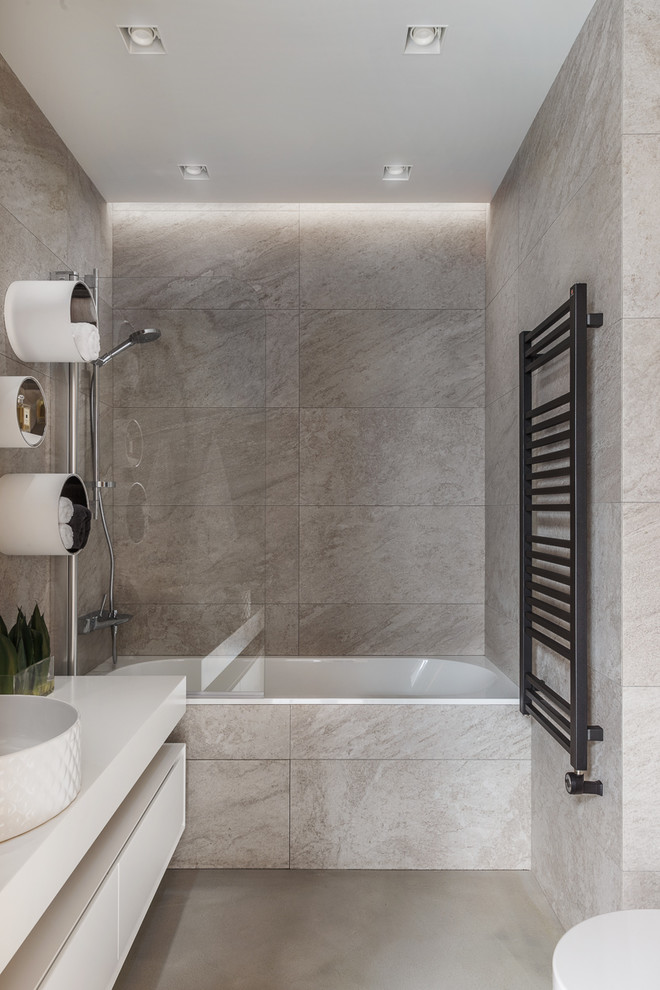 Exempel på ett mellanstort modernt en-suite badrum, med släta luckor, vita skåp, en dusch/badkar-kombination, beige kakel, porslinskakel, betonggolv, bänkskiva i kvarts, grått golv, ett badkar i en alkov och ett fristående handfat