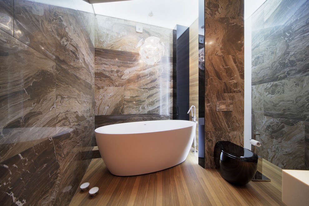 Пример оригинального дизайна: большая главная ванная комната в современном стиле с отдельно стоящей ванной, унитазом-моноблоком, коричневыми стенами и паркетным полом среднего тона