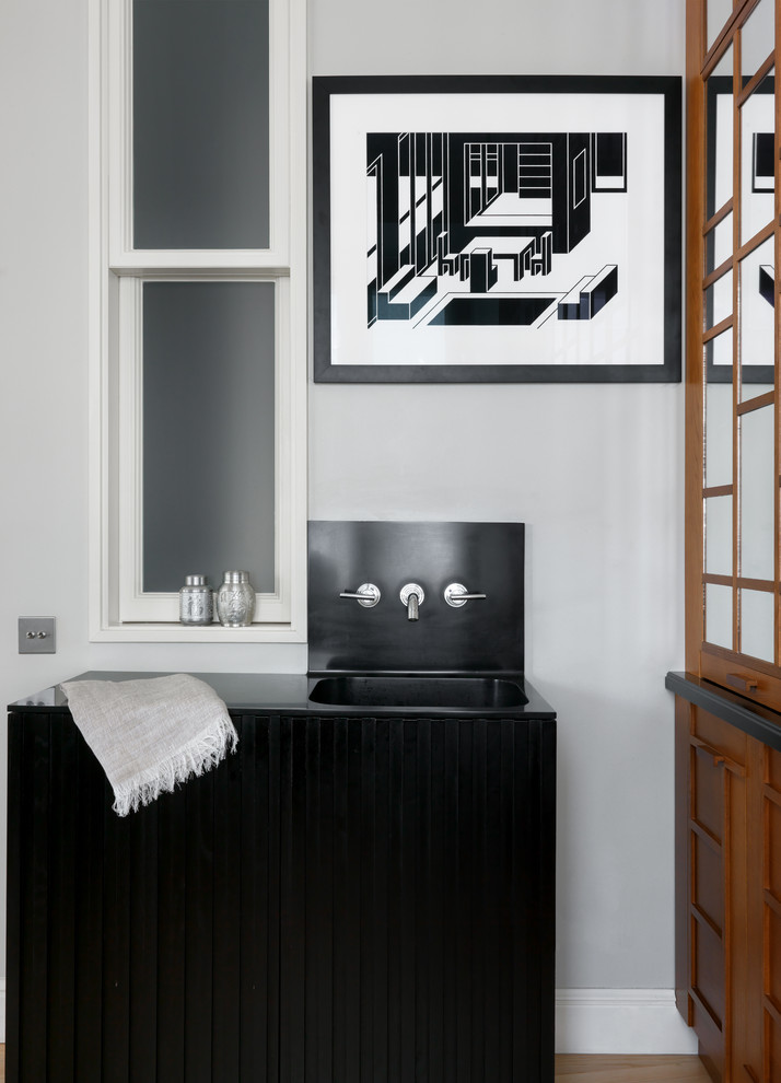 Asiatisches Badezimmer mit schwarzen Schränken, grauer Wandfarbe, integriertem Waschbecken und schwarzer Waschtischplatte in Moskau