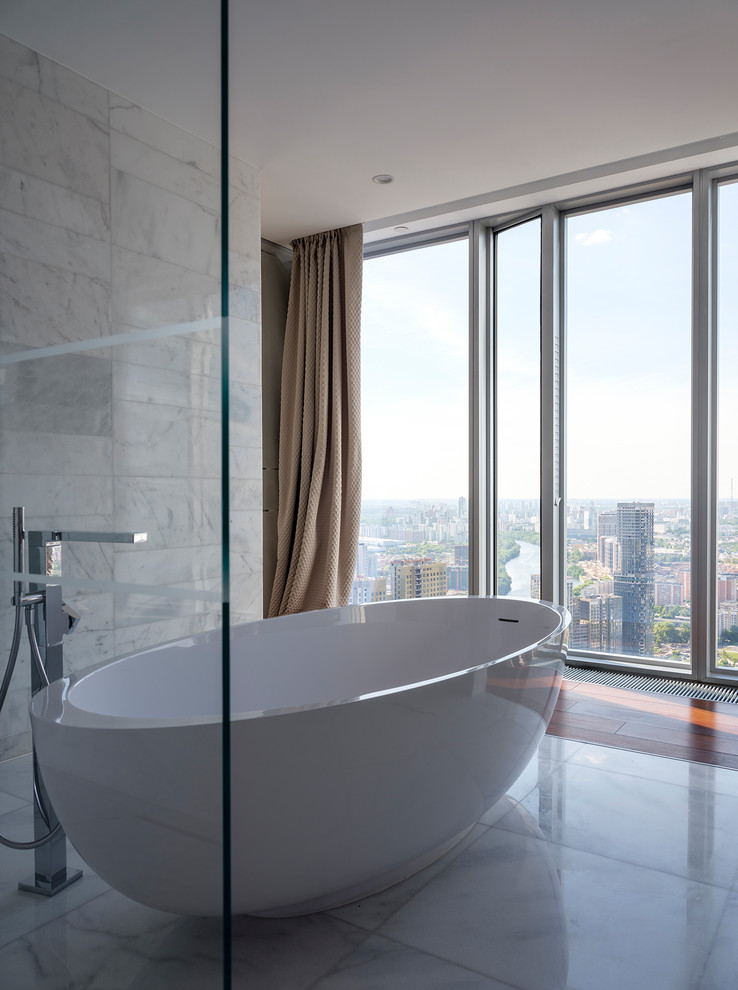 Immagine di una grande stanza da bagno padronale contemporanea con vasca freestanding, piastrelle bianche, piastrelle di marmo, pavimento in marmo e pavimento bianco