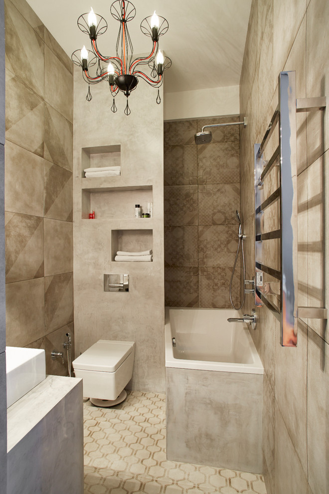 Cette image montre une salle de bain principale design avec un combiné douche/baignoire, un carrelage gris, un mur gris, une vasque et un sol gris.