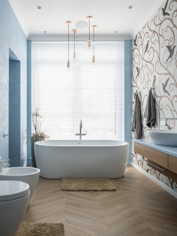 Идея дизайна: совмещенный санузел в современном стиле с отдельно стоящей ванной, синими стенами, душевой кабиной, бежевым полом, подвесной тумбой и плиткой мозаикой