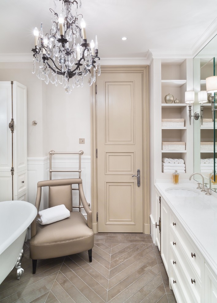 На фото: главная ванная комната в классическом стиле с фасадами с утопленной филенкой, белыми фасадами, ванной на ножках, белыми стенами и врезной раковиной