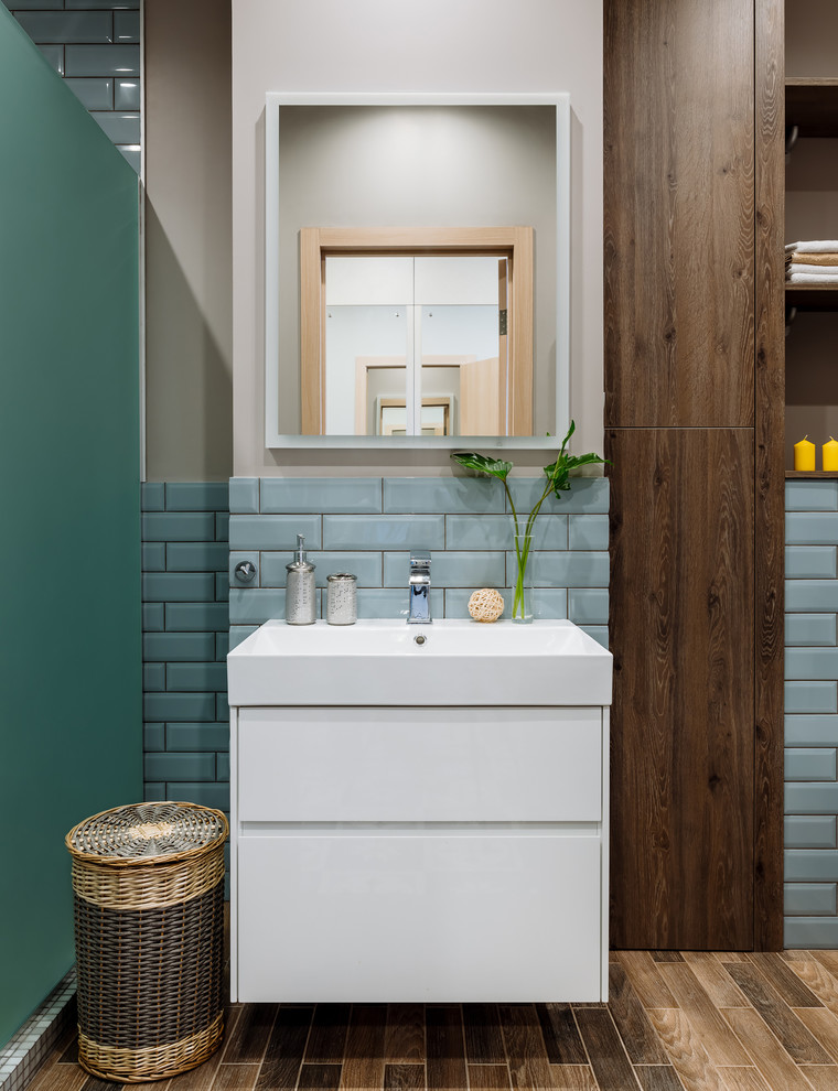 На фото: ванная комната в современном стиле с белыми фасадами, синей плиткой, бежевыми стенами, монолитной раковиной и коричневым полом