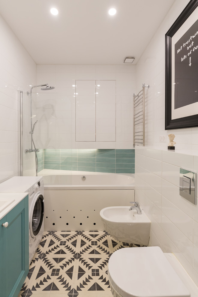 Inredning av ett modernt litet vit vitt en-suite badrum, med turkosa skåp, en dusch/badkar-kombination, en bidé, vit kakel, cementgolv, ett nedsänkt handfat, bänkskiva i akrylsten, flerfärgat golv, luckor med infälld panel, ett badkar i en alkov och keramikplattor
