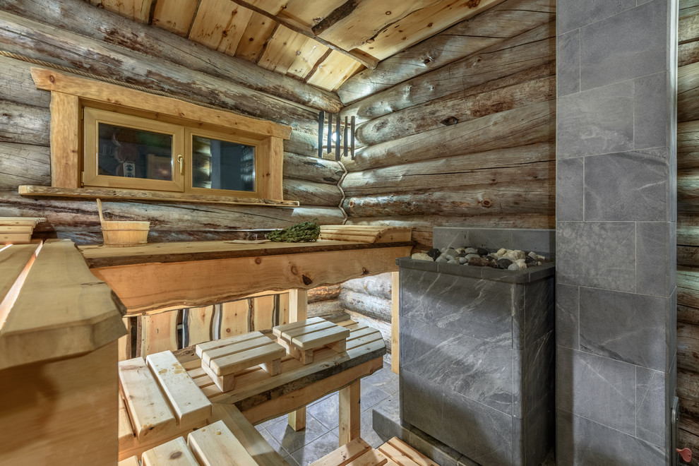 Immagine di una sauna stile rurale con piastrelle grigie, pareti marroni e pavimento grigio