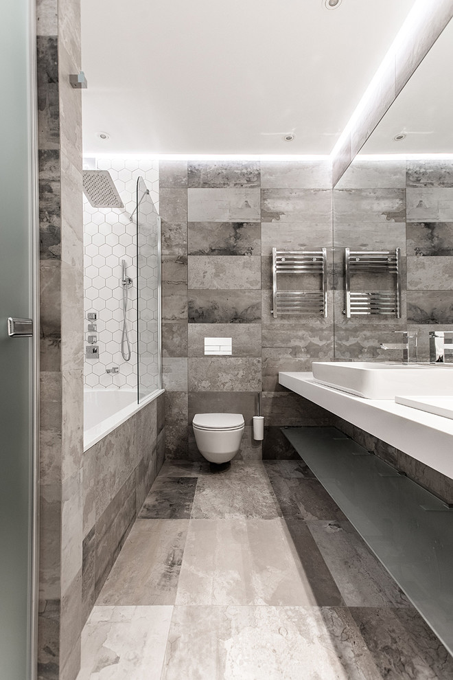 Стильный дизайн: главная ванная комната среднего размера в современном стиле с ванной в нише, инсталляцией, серой плиткой, керамогранитной плиткой, полом из керамогранита, серым полом и настольной раковиной - последний тренд