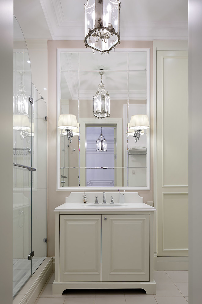 Idées déco pour une petite salle de bain classique avec un plan de toilette en surface solide, une cabine de douche à porte battante, un placard avec porte à panneau surélevé, des portes de placard blanches, un lavabo encastré, un sol beige et un mur rose.