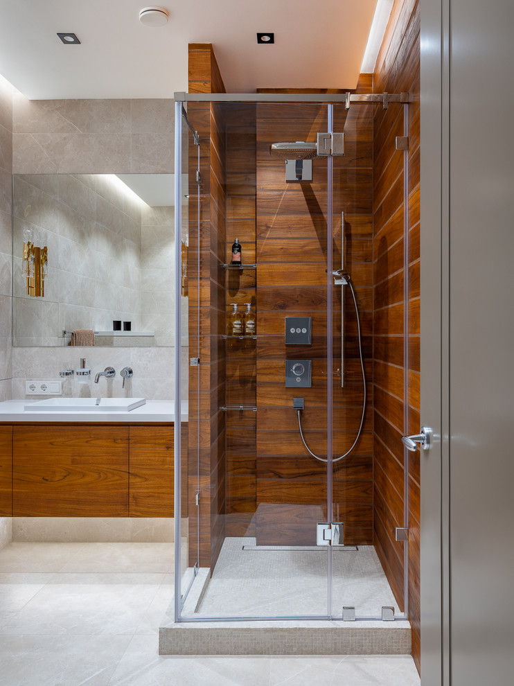 Réalisation d'une salle d'eau design en bois brun avec une douche d'angle, un lavabo posé et un sol gris.