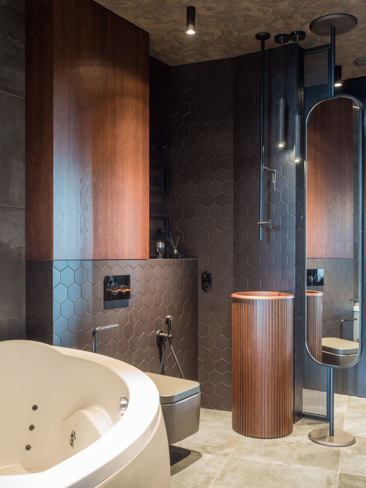 Bild på ett mellanstort funkis en-suite badrum, med släta luckor, skåp i mellenmörkt trä, ett hörnbadkar, våtrum, en vägghängd toalettstol, svart kakel, keramikplattor, grå väggar, klinkergolv i porslin, grått golv och dusch med gångjärnsdörr