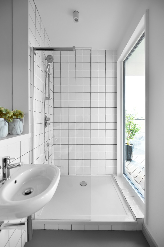Inspiration för skandinaviska badrum, med en hörndusch, vit kakel, vita väggar, ett väggmonterat handfat, grått golv och med dusch som är öppen