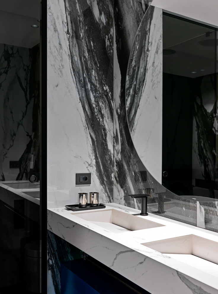 Modern inredning av ett mellanstort vit vitt badrum med dusch, med släta luckor, blå skåp, ett fristående badkar, en dubbeldusch, en vägghängd toalettstol, vit kakel, porslinskakel, bruna väggar, mörkt trägolv, ett väggmonterat handfat, marmorbänkskiva, brunt golv och dusch med skjutdörr