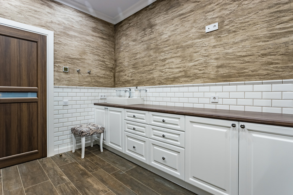 Idéer för stora funkis brunt badrum med dusch, med luckor med infälld panel, vita skåp, en jacuzzi, en dusch i en alkov, en vägghängd toalettstol, vit kakel, tunnelbanekakel, beige väggar, klinkergolv i porslin, ett nedsänkt handfat, träbänkskiva, brunt golv och dusch med gångjärnsdörr
