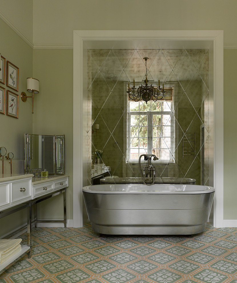 Пример оригинального дизайна: главная ванная комната в классическом стиле с белыми фасадами, отдельно стоящей ванной, зелеными стенами, разноцветным полом, бежевой столешницей, фасадами с утопленной филенкой и фартуком