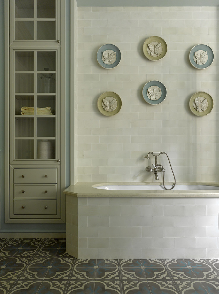 Aménagement d'une salle de bain principale classique avec une baignoire encastrée, un carrelage beige et un sol multicolore.