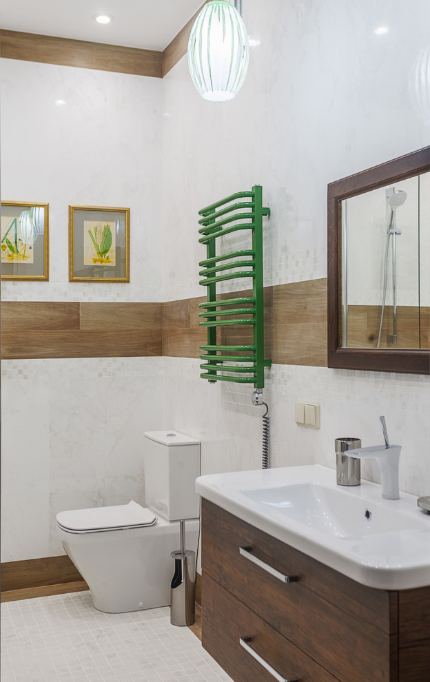 Свежая идея для дизайна: ванная комната в современном стиле с плоскими фасадами, темными деревянными фасадами, раздельным унитазом, белой плиткой и монолитной раковиной - отличное фото интерьера