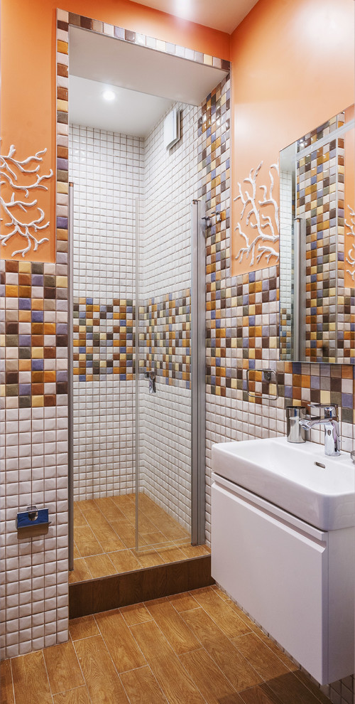 Idée de décoration pour une salle de bain bohème avec un placard à porte plane, des portes de placard blanches, une douche d'angle, un carrelage multicolore, mosaïque, un mur orange et un lavabo posé.