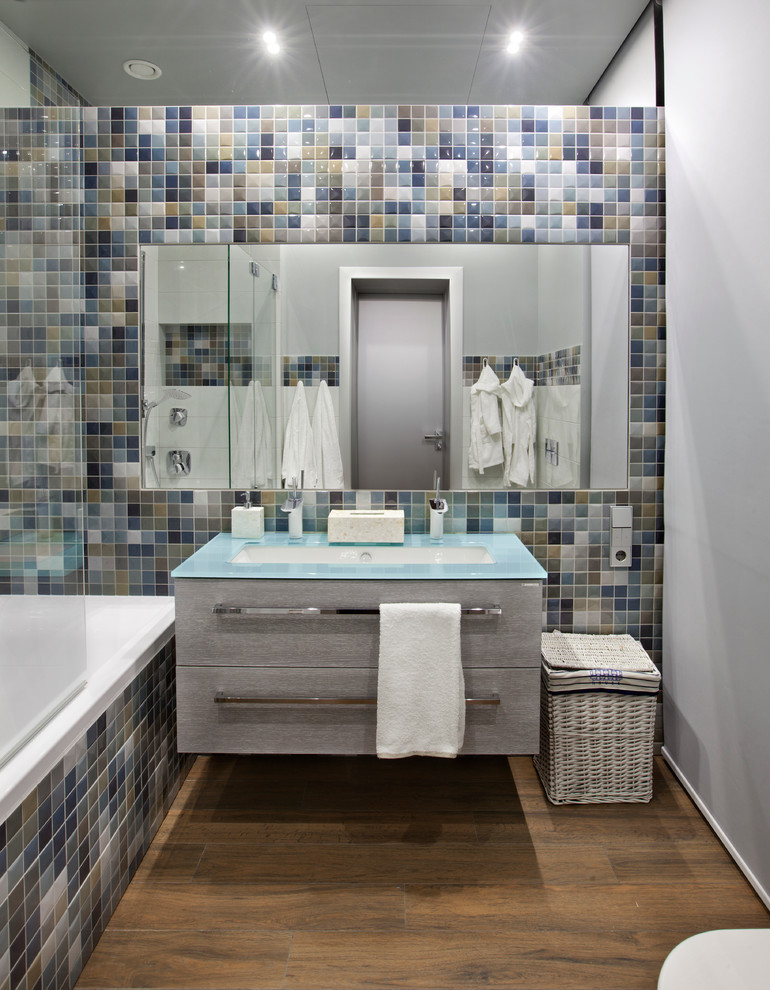 Пример оригинального дизайна: главная ванная комната в современном стиле с плоскими фасадами, серыми фасадами, ванной в нише, душем над ванной, разноцветной плиткой, плиткой мозаикой, серыми стенами, раковиной с несколькими смесителями и открытым душем