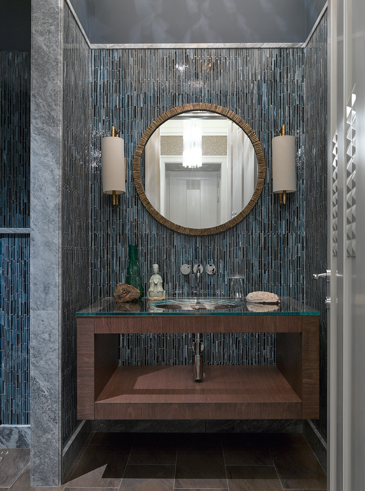 Immagine di una stanza da bagno design con nessun'anta, ante in legno bruno, piastrelle blu, lavabo sottopiano e top in vetro