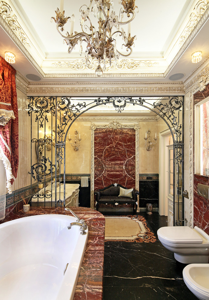 モスクワにある広いヴィクトリアン調のおしゃれなマスターバスルーム (大理石タイル、赤い壁、大理石の床、黒い床、ドロップイン型浴槽) の写真