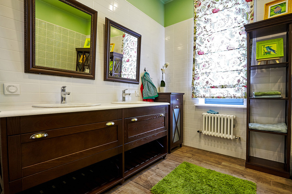 Diseño de cuarto de baño principal con armarios estilo shaker, puertas de armario de madera en tonos medios, baldosas y/o azulejos blancos, paredes verdes y lavabo encastrado