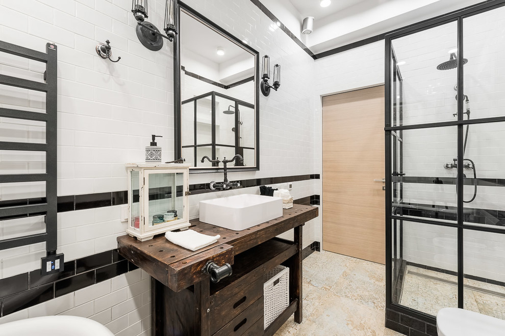 Foto på ett mellanstort industriellt badrum med dusch, med keramikplattor, träbänkskiva, dusch med gångjärnsdörr, släta luckor, skåp i mörkt trä, en hörndusch, svart och vit kakel och ett fristående handfat