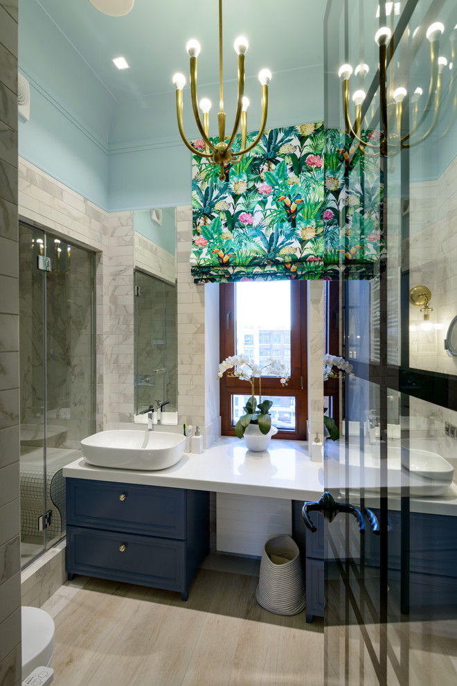 Cette photo montre une salle de bain chic avec un mur bleu, une vasque et un sol beige.
