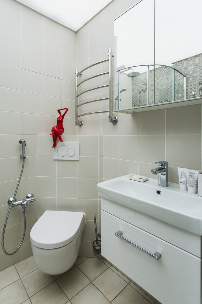 Immagine di una stanza da bagno contemporanea con doccia ad angolo, WC sospeso, piastrelle grigie e lavabo da incasso