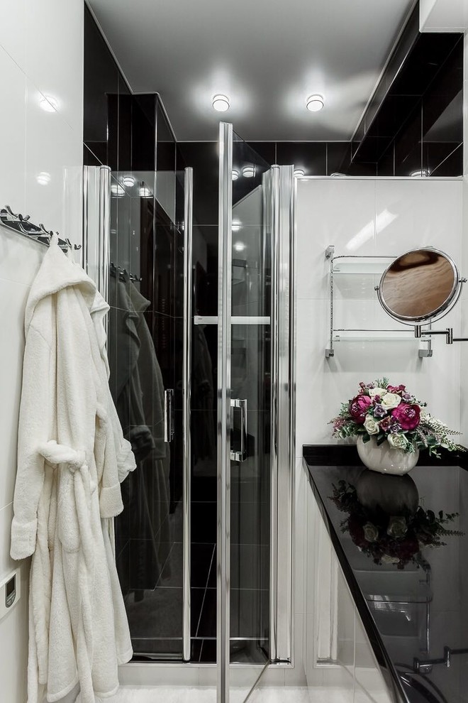 Идея дизайна: ванная комната в современном стиле с белыми фасадами, белой плиткой, черной плиткой, душевой кабиной и белым полом