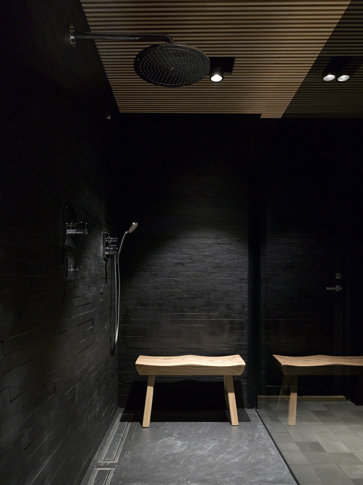 Inredning av ett modernt badrum med dusch, med svart kakel och svart golv