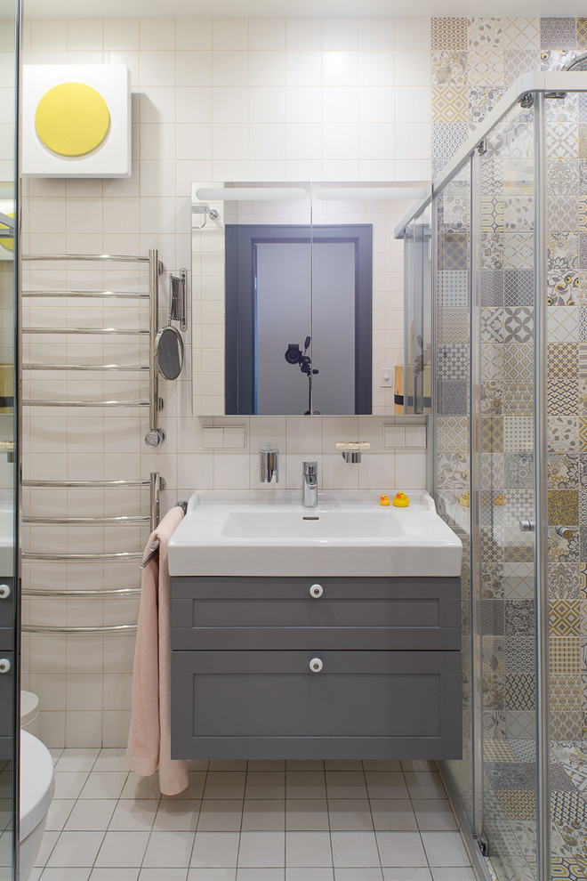 Идея дизайна: ванная комната в скандинавском стиле с фасадами с утопленной филенкой, серыми фасадами, угловым душем, белой плиткой, разноцветной плиткой, душевой кабиной, монолитной раковиной, белым полом и душем с раздвижными дверями