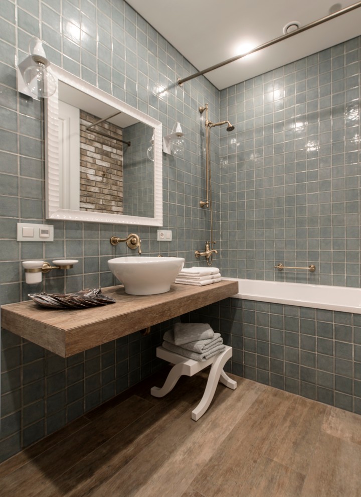 Diseño de cuarto de baño principal clásico de tamaño medio con bañera empotrada, combinación de ducha y bañera, baldosas y/o azulejos de porcelana, paredes verdes, suelo de baldosas de porcelana, lavabo sobreencimera y baldosas y/o azulejos azules