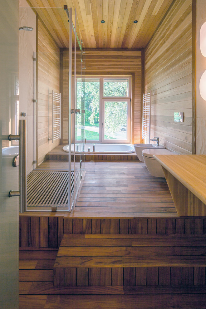 Foto di una grande stanza da bagno padronale contemporanea con WC sospeso, piastrelle in gres porcellanato, pavimento in legno massello medio, top in legno e vasca da incasso