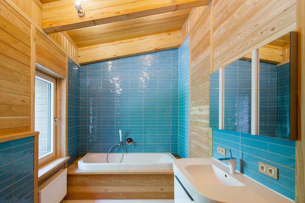 Свежая идея для дизайна: маленькая детская ванная комната в современном стиле с черной плиткой, керамической плиткой, синими стенами, полом из керамической плитки, подвесной раковиной, накладной ванной и душем над ванной для на участке и в саду - отличное фото интерьера