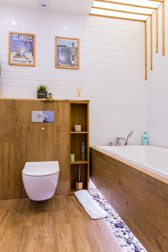 Idée de décoration pour une salle de bain principale bohème avec WC suspendus, un carrelage blanc, un carrelage métro et un sol marron.