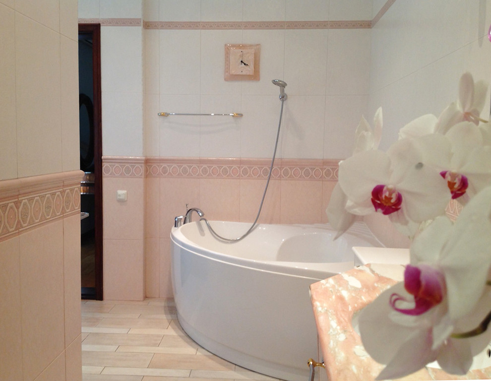 На фото: большая главная ванная комната в классическом стиле с плоскими фасадами, угловой ванной, угловым душем, раздельным унитазом, розовой плиткой, керамической плиткой, розовыми стенами, полом из керамической плитки, раковиной с несколькими смесителями, мраморной столешницей, розовым полом и душем с раздвижными дверями с