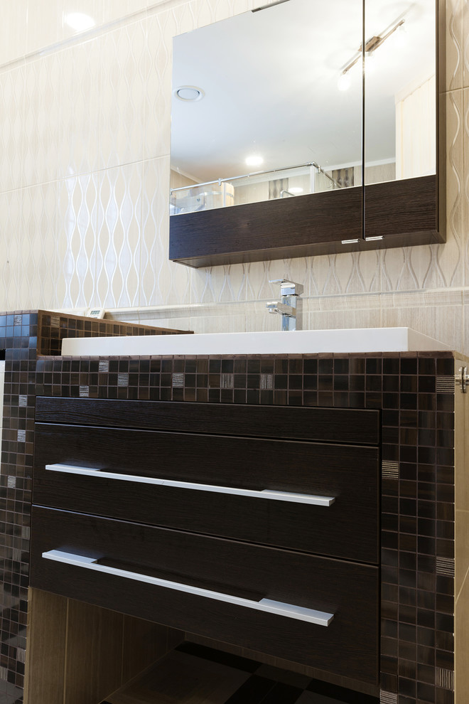 Inspiration pour une grande salle de bain principale design en bois foncé avec un placard à porte plane et un carrelage gris.