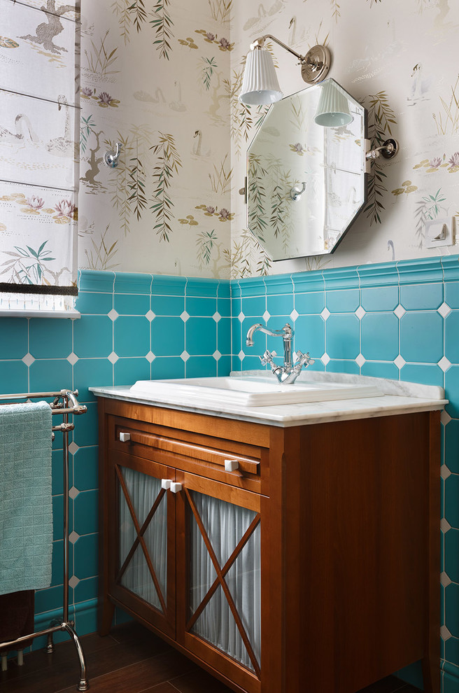 Immagine di una stanza da bagno tradizionale con ante in legno scuro, pareti beige, lavabo da incasso e top in marmo