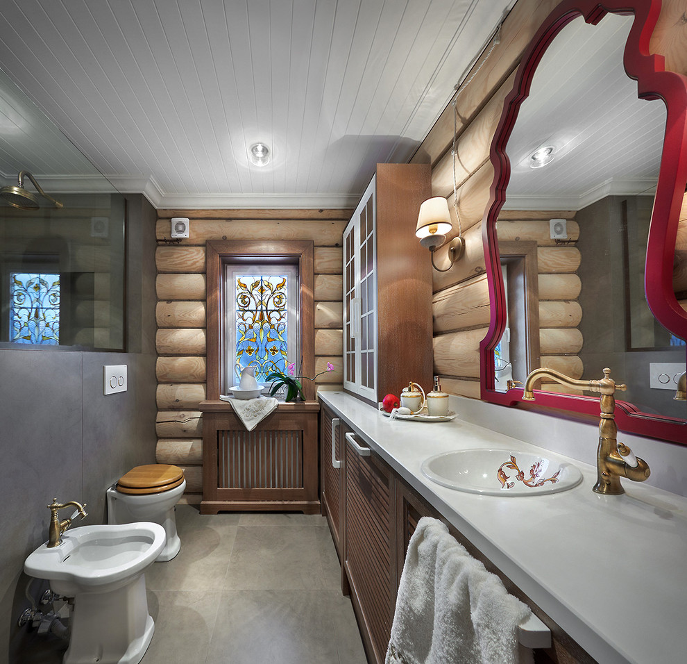 На фото: ванная комната в деревянном доме в современном стиле с фасадами с филенкой типа жалюзи, коричневыми фасадами, душем в нише, биде, серой плиткой, коричневыми стенами, душевой кабиной и накладной раковиной