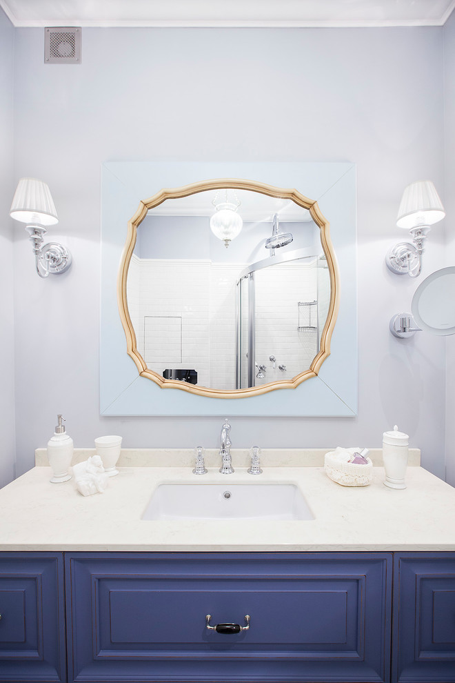Immagine di una stanza da bagno tradizionale con ante con bugna sagomata, ante viola, pareti viola, lavabo sottopiano e top in marmo