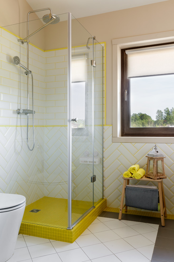 Aménagement d'une grande salle de bain grise et jaune contemporaine pour enfant avec des carreaux de porcelaine, un mur beige, un sol en carrelage de porcelaine, une cabine de douche à porte battante, une douche d'angle, un sol gris, WC séparés et un carrelage blanc.
