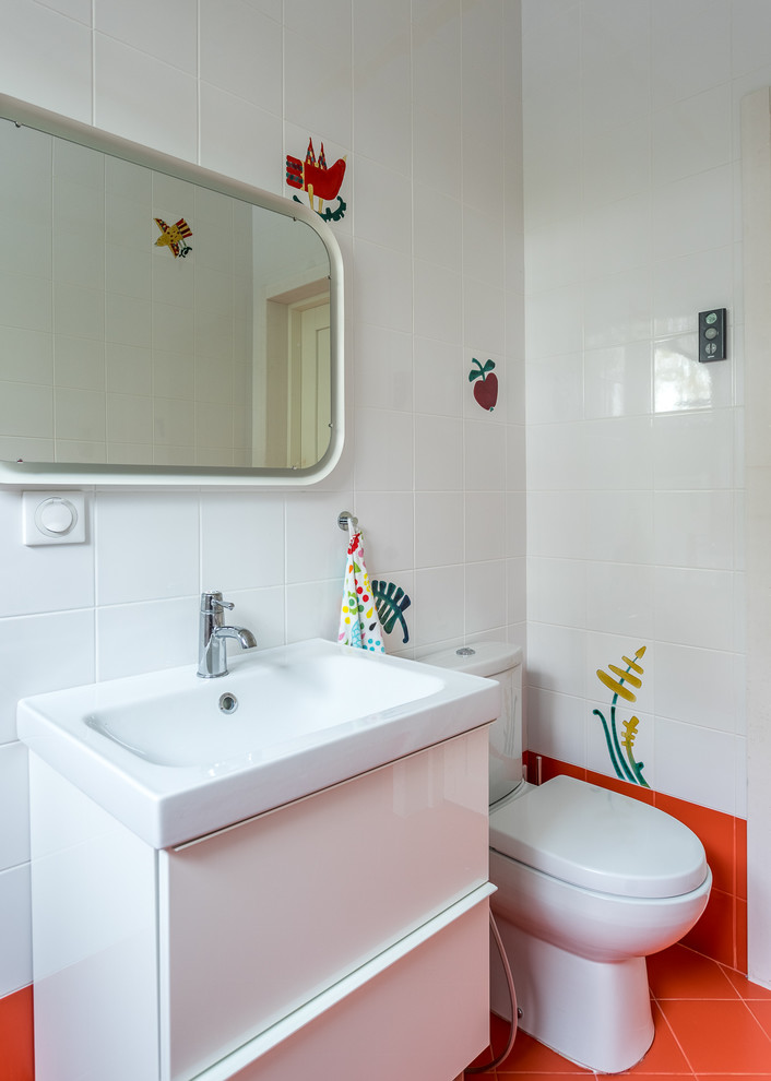 Réalisation d'une salle de bain nordique de taille moyenne avec un placard à porte plane, des portes de placard blanches, WC séparés, un carrelage blanc, des carreaux de céramique, un sol en carrelage de porcelaine, un lavabo posé et un sol rouge.