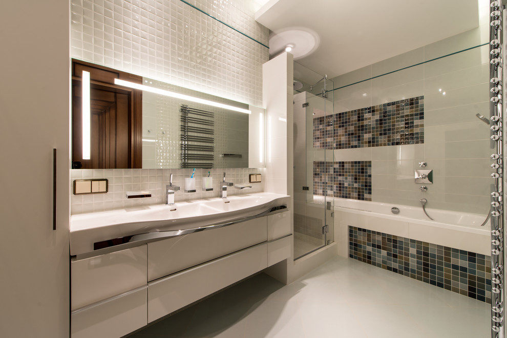 Contemporary bathroom in Moscow with white cabinets, an alcove bath, an alcove shower, white tiles, multi-coloured tiles and a trough sink.