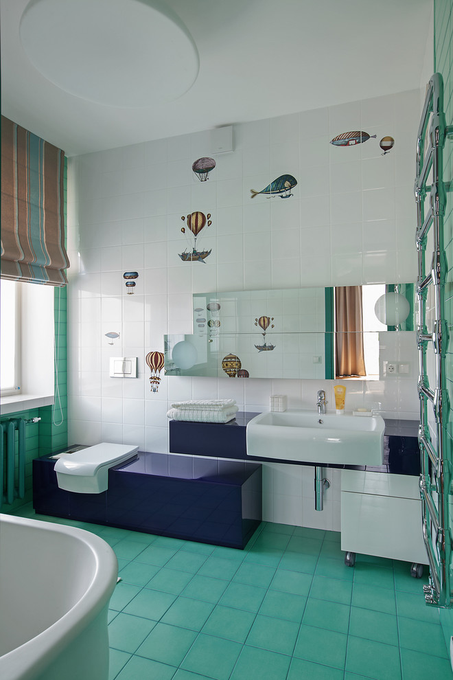 Foto på ett mellanstort funkis badrum för barn, med släta luckor, blå skåp, vit kakel, keramikplattor, klinkergolv i keramik, en toalettstol med separat cisternkåpa och ett nedsänkt handfat