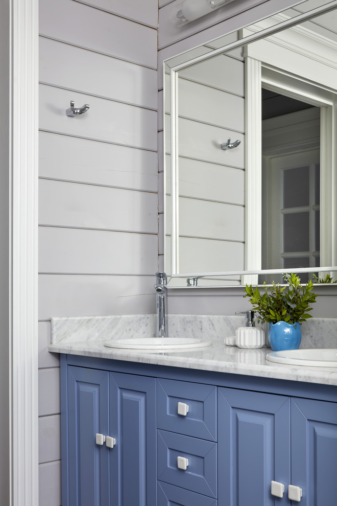 Ejemplo de cuarto de baño de estilo de casa de campo con armarios con paneles con relieve, puertas de armario azules, paredes grises, lavabo encastrado y encimeras grises