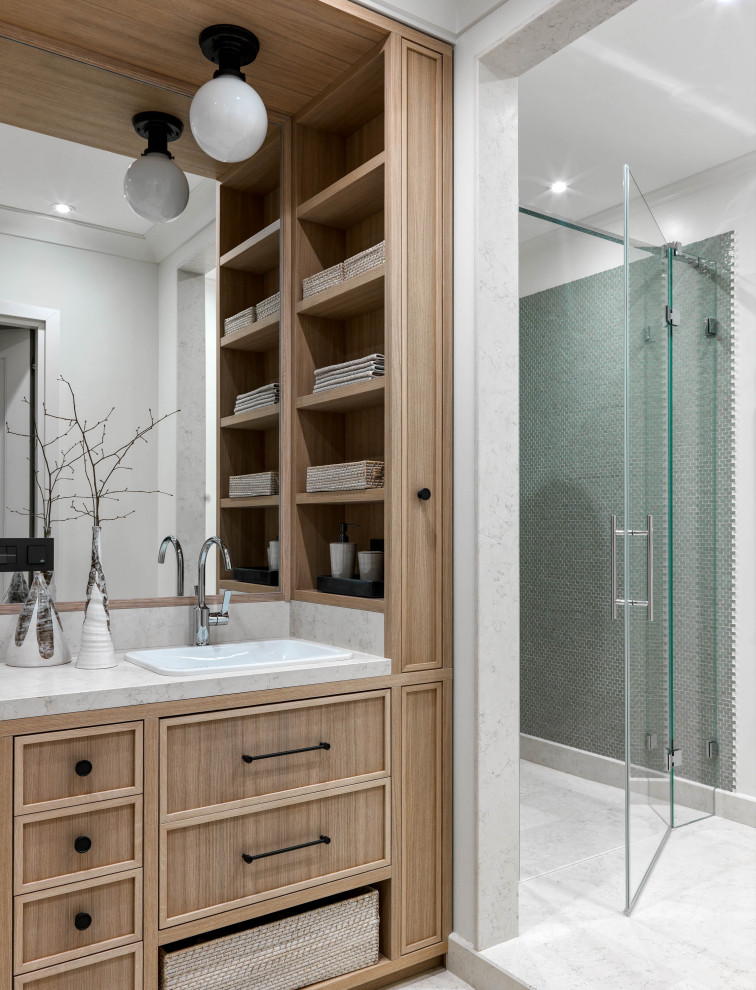 This is an example of a medium sized contemporary family bathroom in Moscow with recessed-panel cabinets, light wood cabinets, green tiles, mosaic tiles, white walls, marble flooring, a built-in sink, marble worktops, white floors, a hinged door, white worktops and an alcove shower.