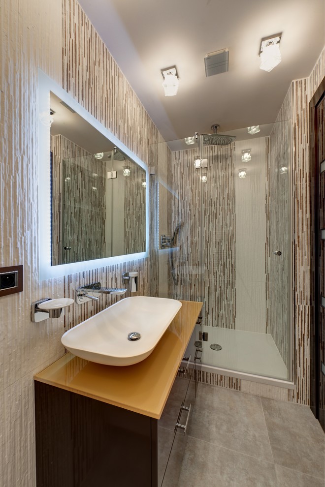 Modelo de cuarto de baño largo y estrecho actual con armarios con paneles lisos, ducha empotrada, lavabo sobreencimera y espejo con luz