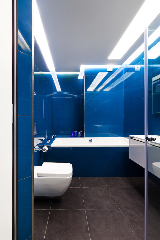 На фото: маленькая главная ванная комната в современном стиле с плоскими фасадами, инсталляцией, синими стенами, белыми фасадами, ванной в нише и синей плиткой для на участке и в саду с
