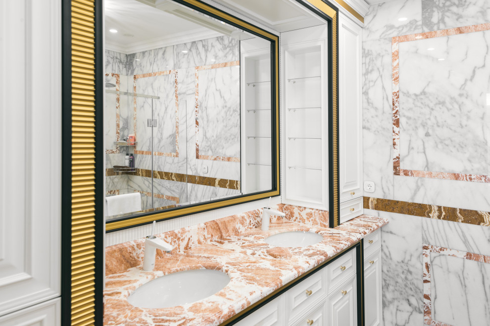 Idées déco pour une salle de bain principale classique de taille moyenne avec un placard avec porte à panneau surélevé, des portes de placard blanches, un espace douche bain, WC suspendus, un carrelage blanc, du carrelage en marbre, un mur blanc, un sol en marbre, un lavabo intégré, un plan de toilette en marbre, un sol blanc, une cabine de douche à porte battante, un plan de toilette orange, des toilettes cachées, meuble double vasque et meuble-lavabo encastré.