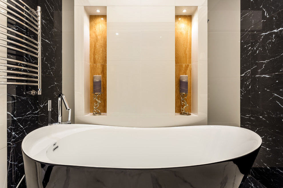 На фото: ванная комната среднего размера в стиле неоклассика (современная классика) с черными фасадами, отдельно стоящей ванной, бежевой плиткой, бежевыми стенами, разноцветным полом, черной столешницей, нишей и многоуровневым потолком